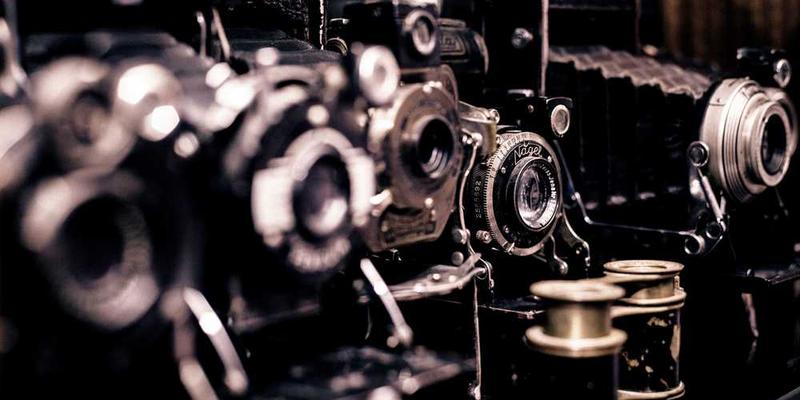 现代家居照片墙布置案例，展示多张大小不一的照片组合在墙面，周围留有空间用于装饰点缀，展现简约而不简单的氛围