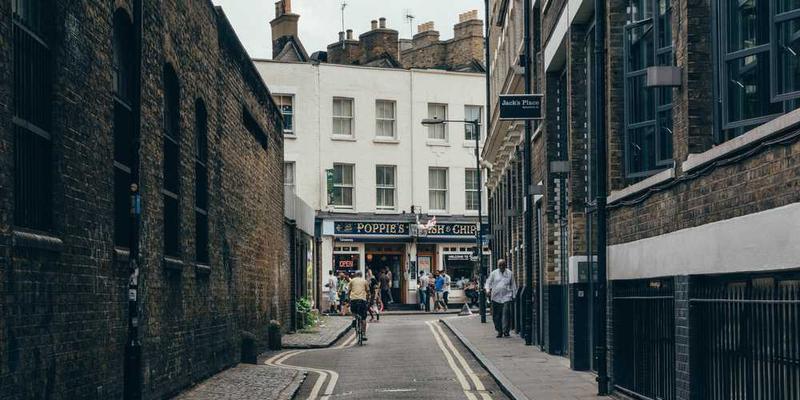 晴朗的天气下，人们聚集在户外公共长椅上悠闲地交谈；阴雨天气时，长椅上空空如也，仅有少数人匆匆走过。