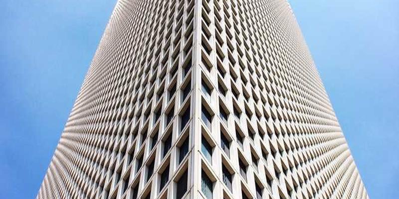 一位年轻人捧着一部报废智能手机，神情哀伤