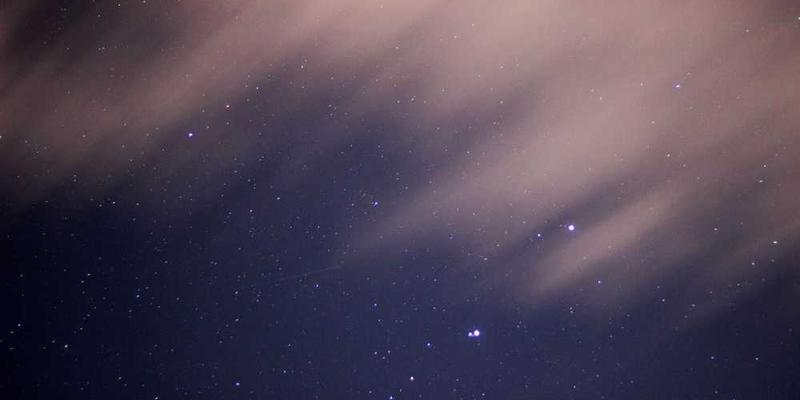 一双鞋的鞋底，上面有明显的磨损和纹路，背景为城市街道